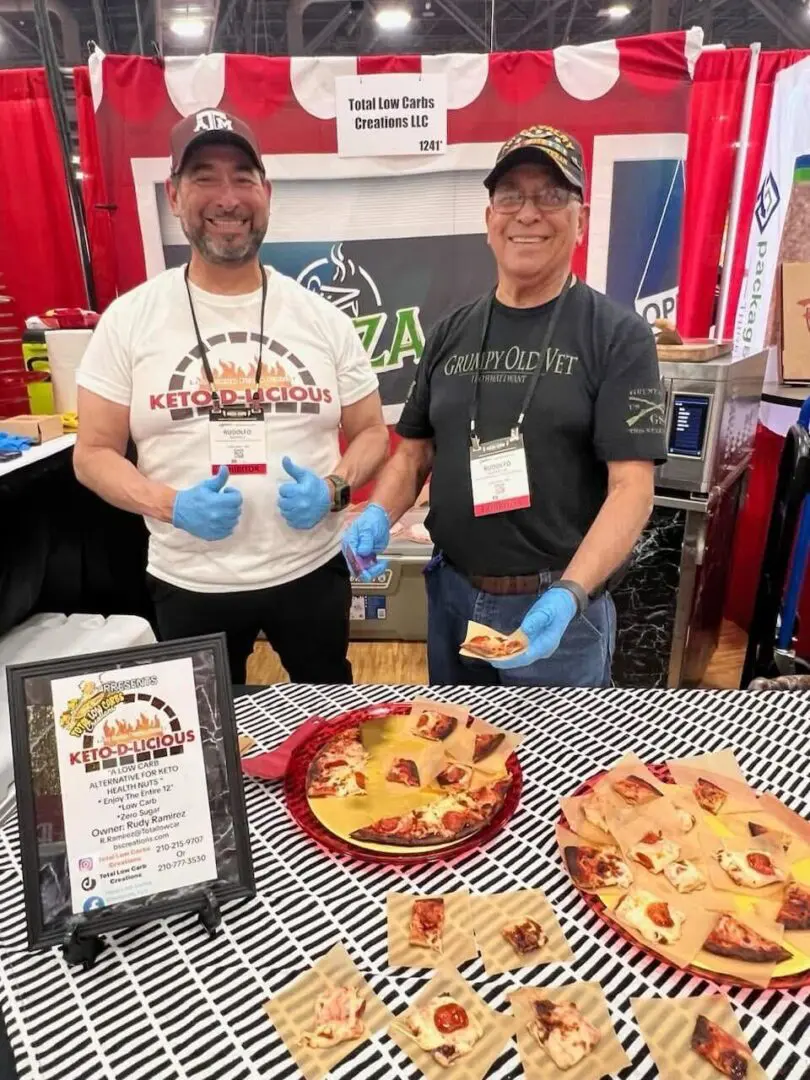 Two men at a food booth display.